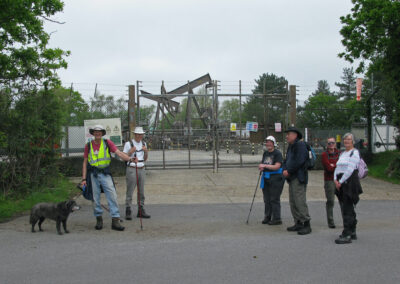 Photo of walkers outside Wytch Farm Oil Extraction Facility with "nodding donkey" pumpjack in the background – May 8, 2024