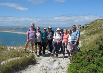 Photo of walkers with Chesil Bank in the distance – June 22, 2024