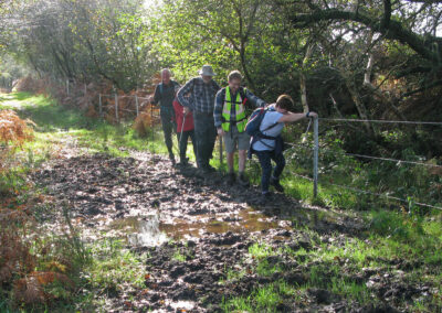 Photo of walkers tackling a very muddy footpath – October 19, 2024