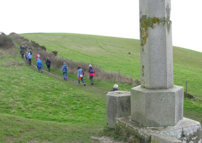 Photo of walkers passing the obelisk on Ballard Down – January 15, 2025