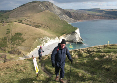 Photo of walkers climbing Bindon Hill with Arish Mell and Flowers Barrow in the distance – February 9, 2025