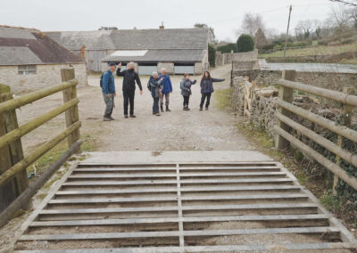 Photo of walkers near the dam that once supplied water to power the 19th Century water wheel at Blashenwell Farm – February 15, 2025